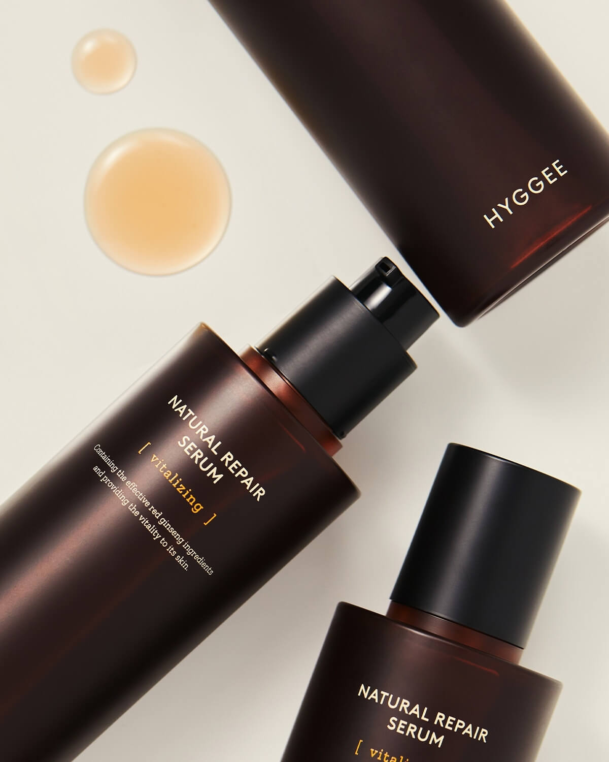 Two HYGGEE Natural Repair Serum bottles with a cap. Vitalizing essence drops for skin vitality.