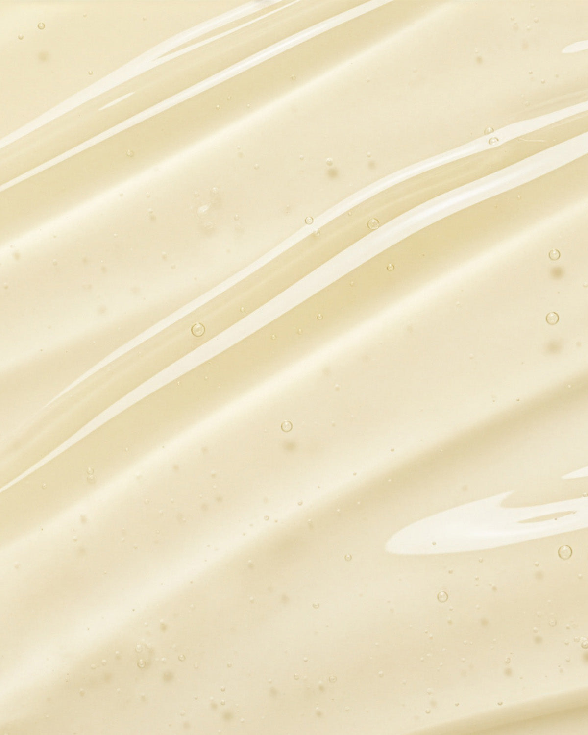 Close-up texture of Purito Pure Vitamin C Serum showing a clear, viscous liquid with small air bubbles.