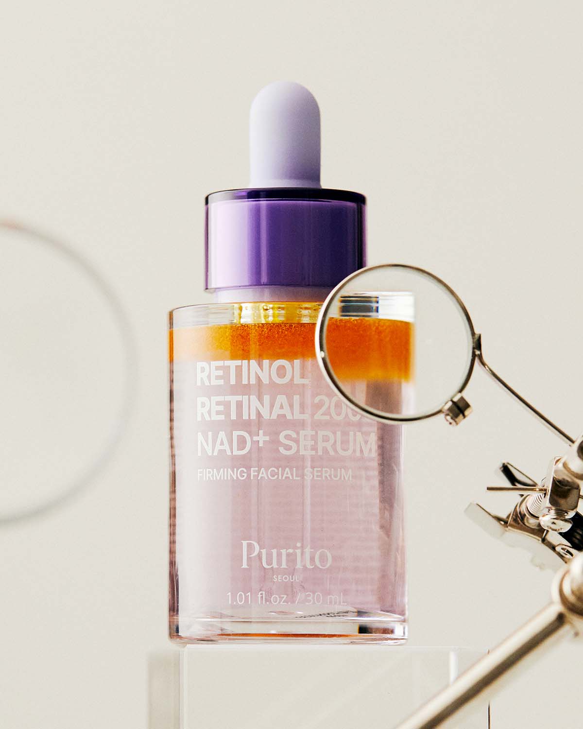 Purito Retinol serum bottle being inspected through a magnifying glass to show product details.