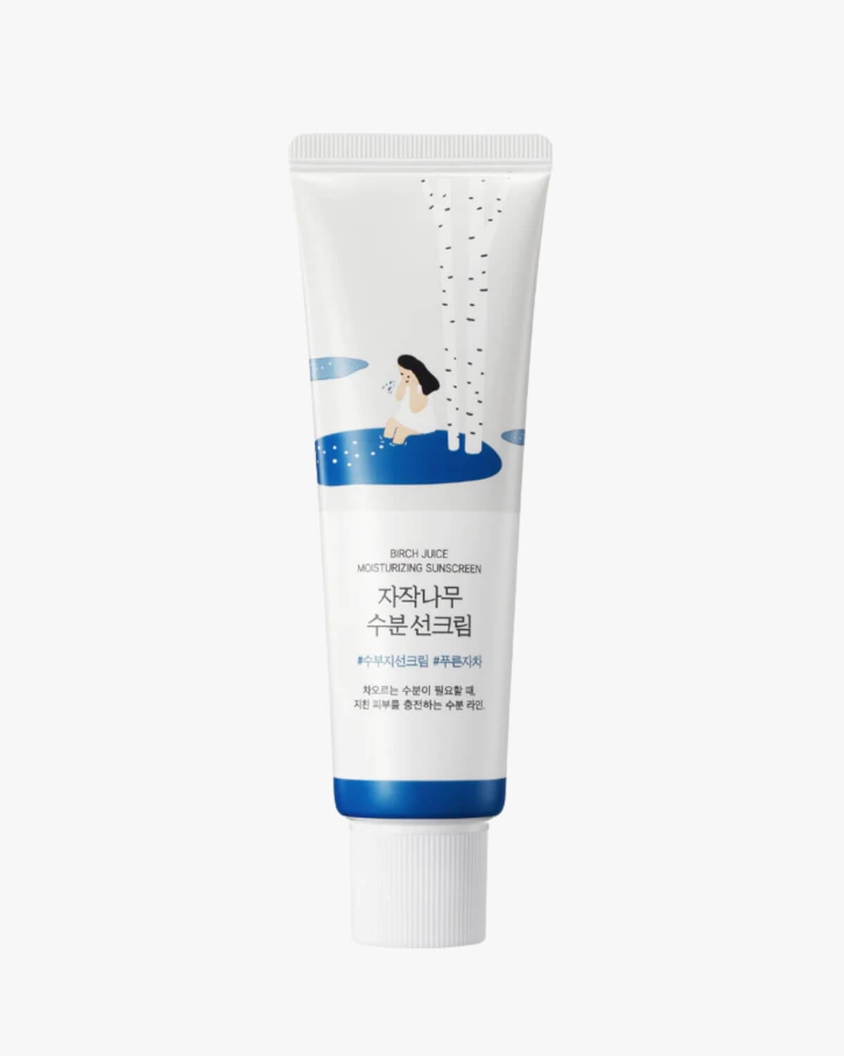 A white tube of Round Lab Birch Juice Moisturizing Sunscreen featuring an illustration of a person by a tree.