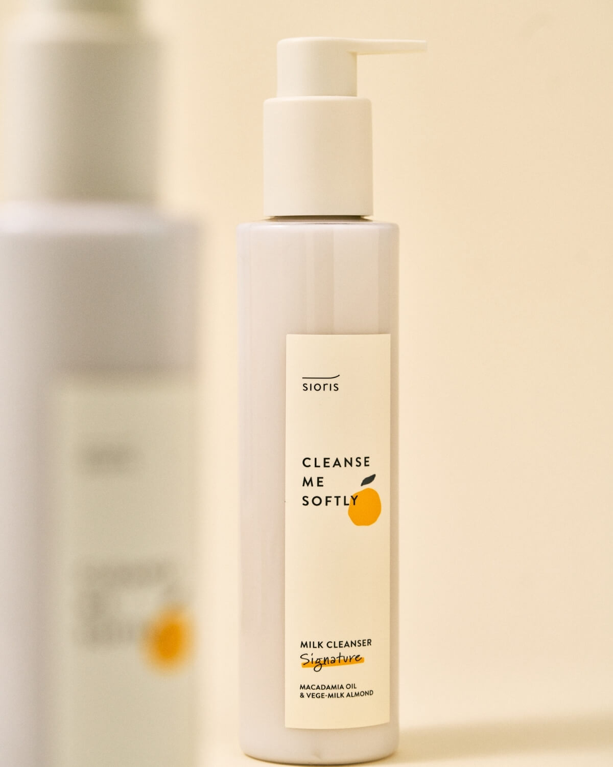 Close-up of Sioris Cleanse Me Softly bottle with another bottle blurred in the background.