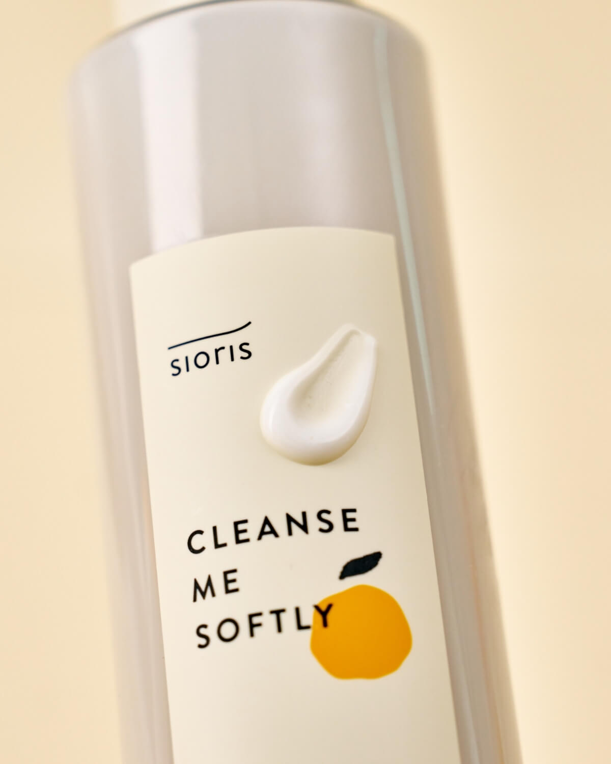 Close-up of the Sioris bottle label with a dollop of white cream cleanser on the surface.