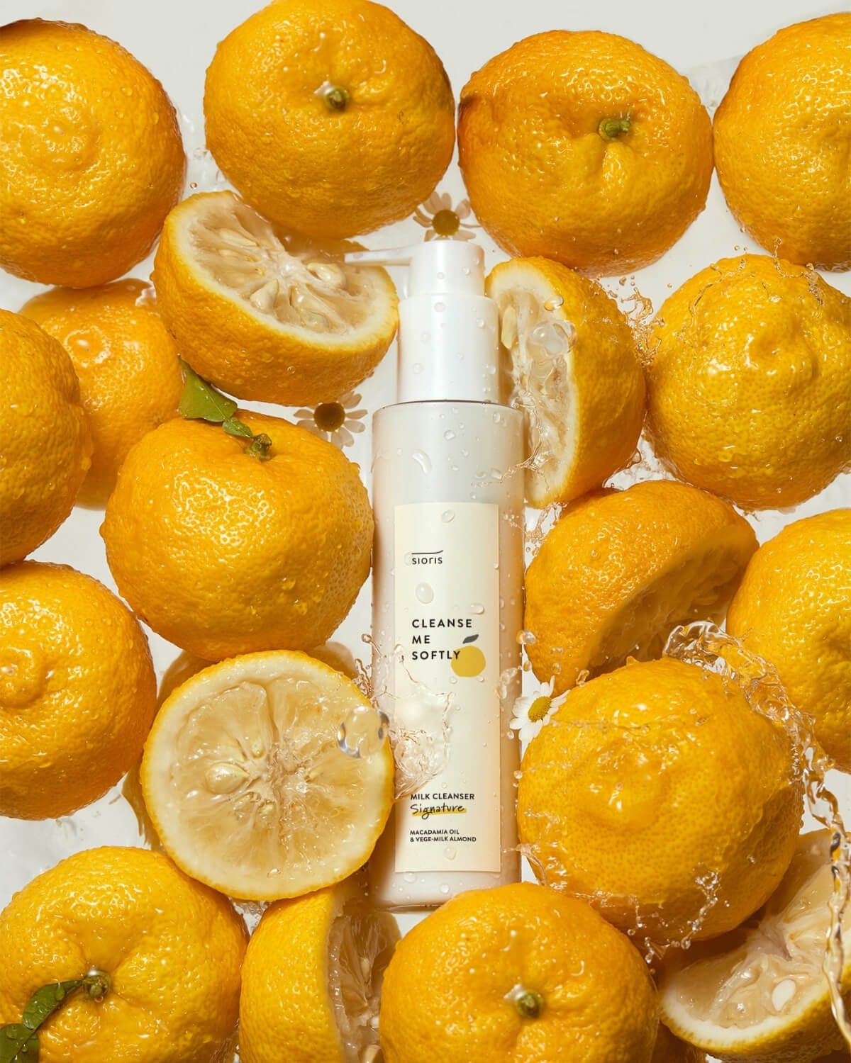 Sioris cleanser bottle surrounded by floating citrus fruits and water splashes.