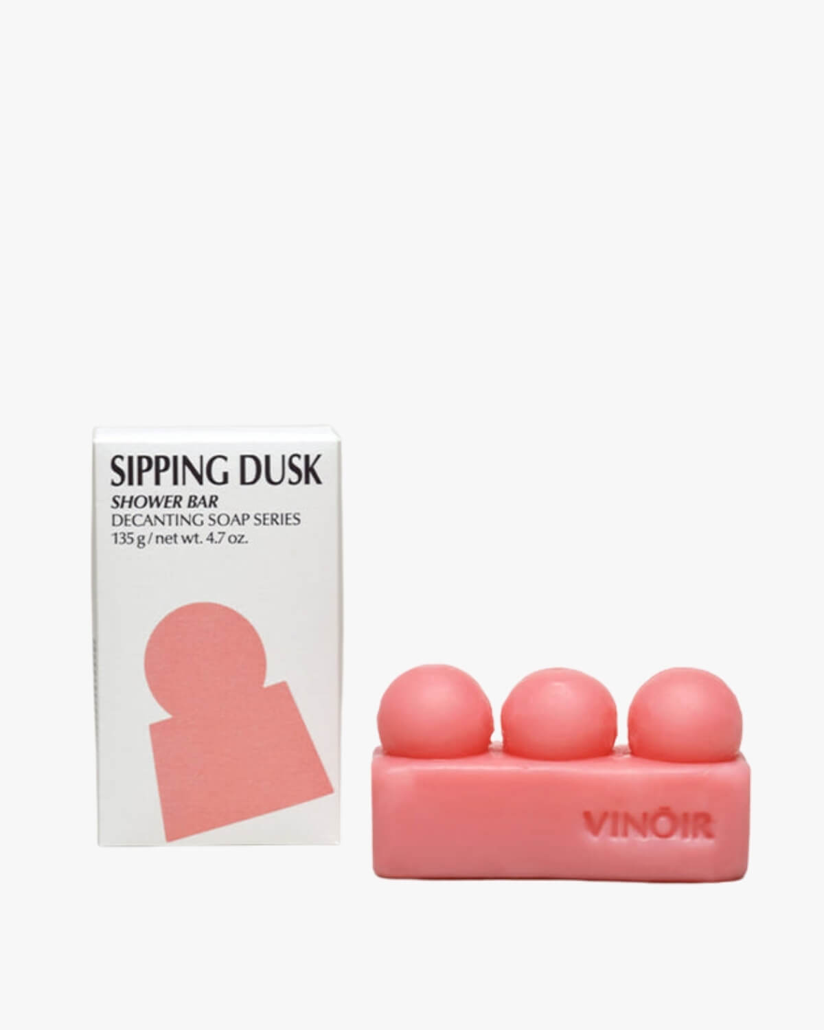 VINŌIR Sipping Dusk Shower Bar in a white background alongside its white and pink branded box packaging.