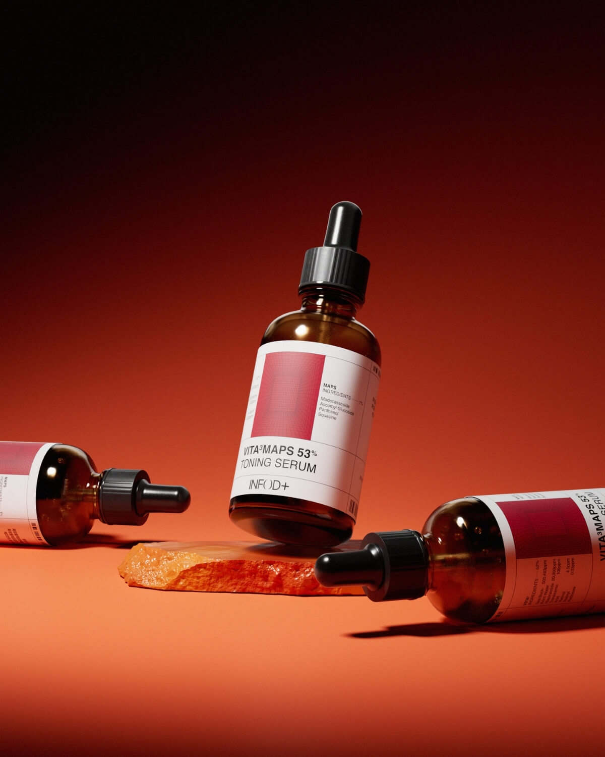 Three brown glass dropper bottles of VITA³MAPS Toning Serum are arranged on an orange surface with a glowing, textured orange rock in the center. The background is a gradient of orange and black.