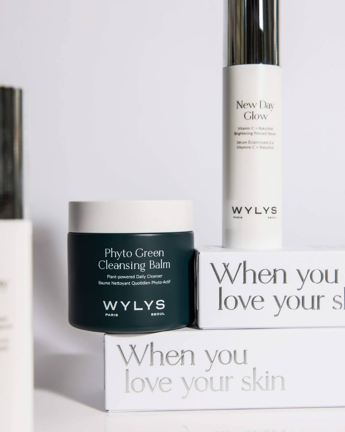 WYLYS skincare set featuring Phyto Green Cleansing Balm and New Day Glow Serum on branded white packaging boxes.