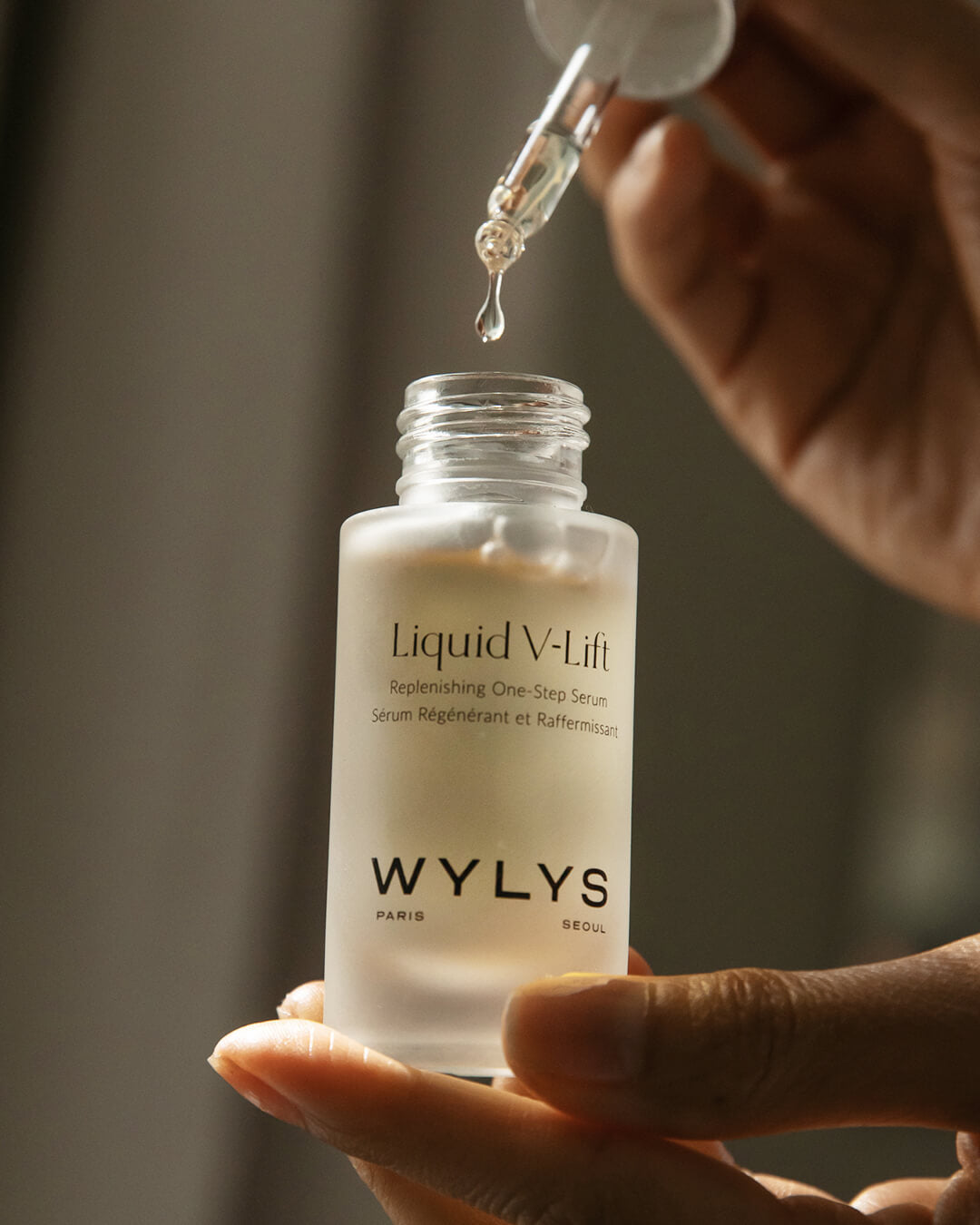 WYLYS Liquid V-Lift One-Step Serum Bottle in Hands When You Love Your Skin One-Step Replenishing Peptide serum to help lift and hydrate. Texture. Close-up.