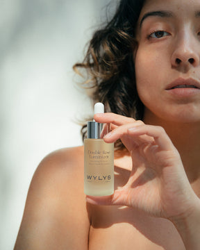 WYLYS Double Rose Luminizer Bottle held by Woman When You Love Your Skin